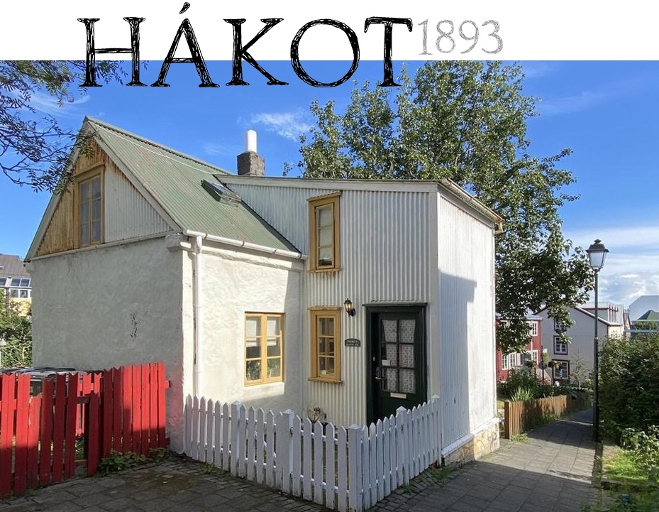 HÁKOT, a historical dolerite stone house built in 1893, featuring a unique design with a green roof, wooden details, and a white exterior, situated in Grjótaþorp, Reykjavík.
